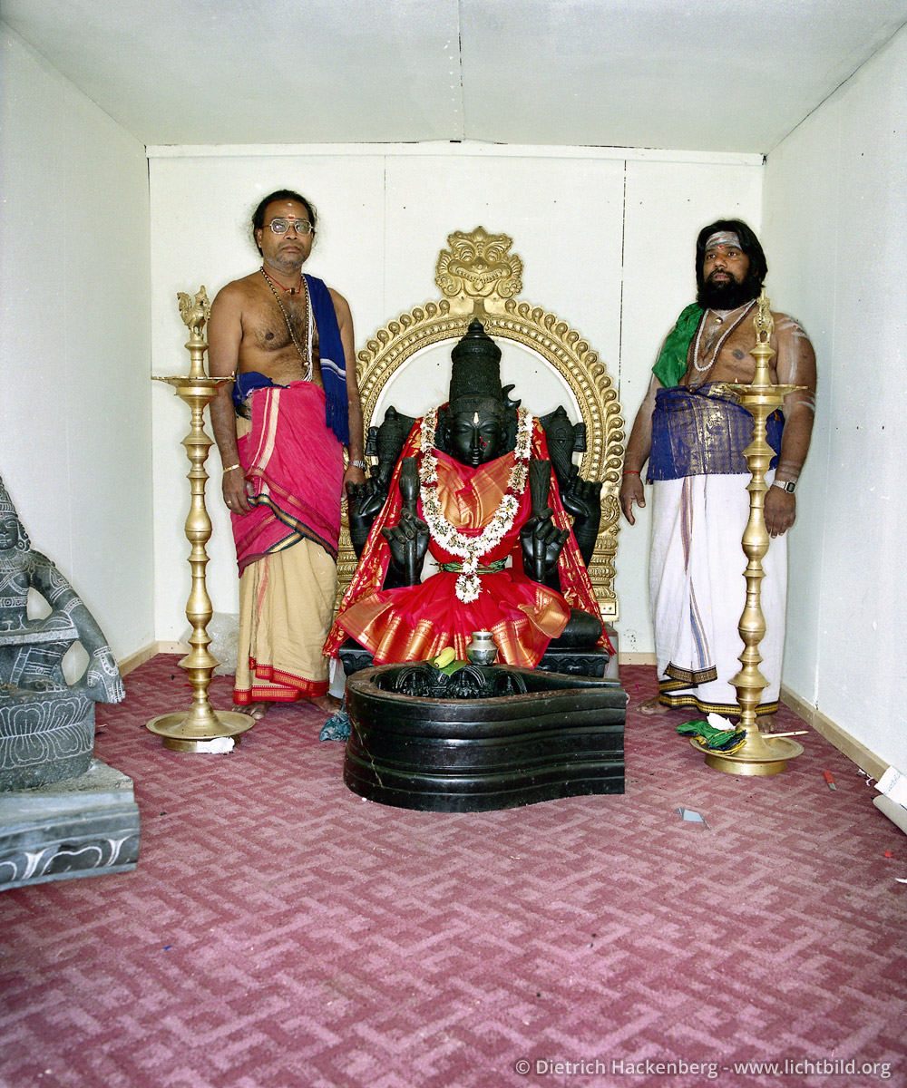 Priester und Tempeldiener neben der Göttin Sri Kamadschi Ampal - Hindutempel, Hamm-Uentrop - Bis zur Fertigstellung des Tempel steht die Göttin in einem Container. Foto © Dietrich Hackenberg