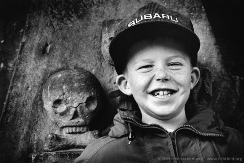 Sommersprossen und Totenkopf - Miltenberg, Bayern - Amerikanischer Touristenjunge vor einem alten Grabstein Sommersprossen und Totenkopf - Foto © Dietrich Hackenberg