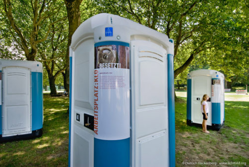 Ein Mädchen öffnet eine der Mobiltoiletten - Ausstellung BESETZT im Niederrhein-Stadion Oberhausen - Foto © Dietrich Hackenberg
