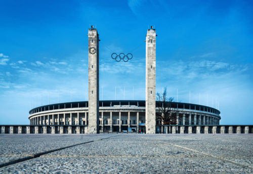 Olympiastadion Olympischer Platz 3, 14053 Berlin Foto © Dietrich Hackenberg Im August 1936 richtet Nazideutschland in Berlin die Olympischen Spiele aus. Die Linke in Europa protestiert. Eine Diktatur, die politische Gegner ins Konzentrationslager steckt, massive Kriegsrüstung betreibt und jüdische Sportler ausschliessen will, darf nicht Veranstalter der Weltspiele werden. In Barcelona wird mit Unterstützung der katalanischen Regionalregierung eine „Volksolympiade“ organisiert. [...] Glauben Sie mir, diejenigen der internationalen Sportler, die nach Berlin gehen, werden dort nichts anderes sein als Gladiatoren, Gefangene und Spaßmacher eines Diktators, der sich bereits als Herr dieser Welt fühlt. [...]Rede Heinrich Manns auf der Konferenz zur Verteidigung der Olympischen Idee am 6. und 7. Juni 1936 in Paris Die Auftaktveranstaltung der Gegenolympiade hat man wegen des grossen Zuspruchs um drei Tage vor verlegt. Doch am frühen Morgen dieses 19. Juli rücken putschende Offiziere aus ihren Kasernen aus, um im Handstreich die linke katalanische Regierung zu stürzen. Der Putsch des General Franco, Beginn des drei Jahre dauernden Bürgerkrieges, hat auf Barcelona übergegriffen. Barrikaden, hastig aufgetürmt von der Bevölkerung Barcelonas, stoppen den Vormarsch der Aufständischen. Das Stadion wird jetzt zum Zentrum der ausländischen Freiwilligen, die sich melden, um gegen Francos Truppen zu kämpfen.
