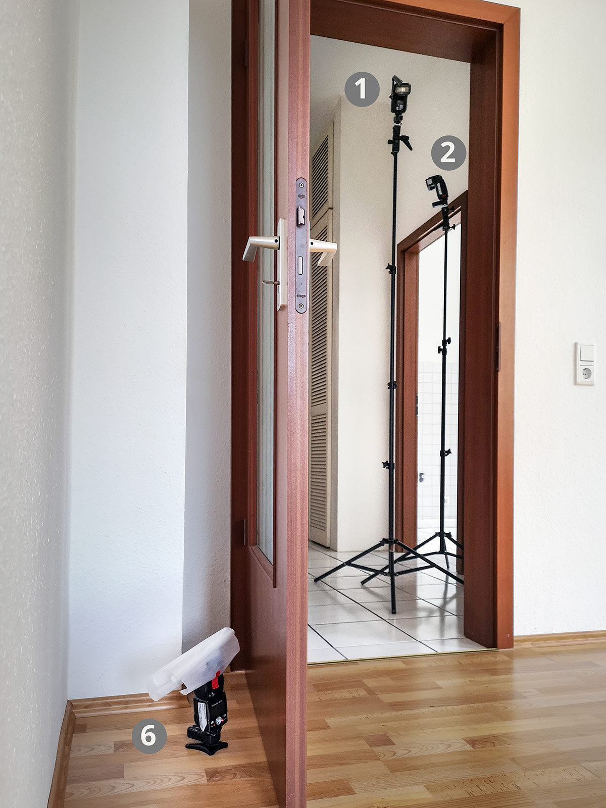 Das Licht vom Blitz 6 auf dem Boden hinter der Glastüre wird durch "Frostfolie" weicher gemacht und gestreut. Effekt: Durchsicht der Glastür wird betont und die Tür selbst akzentuiert durch einen hellen Schein.