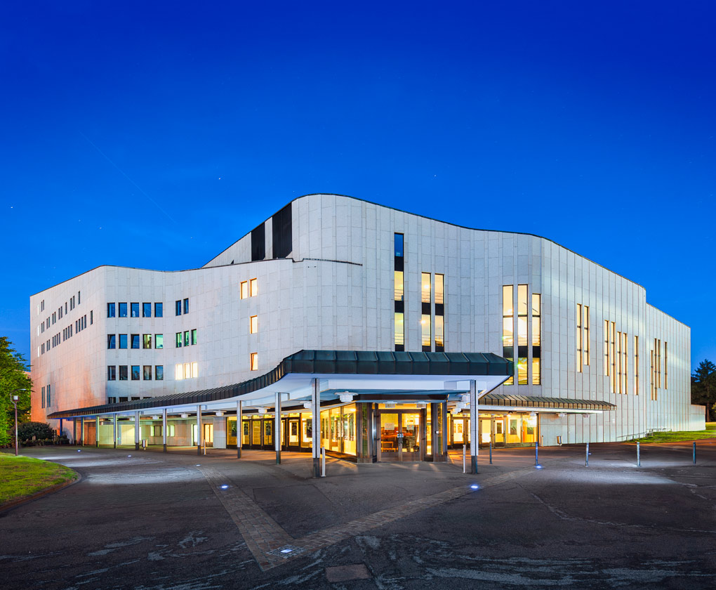 Front Aalto-Theater bei Nacht, Essen Das Aalto-Theater ist das Opernhaus der Stadt Essen. 1959 hatte sich eine Jury einstimmig für den Entwurf des finnischen Architekten Alvar Aalto entschieden. Erst 1983, sieben Jahre nach dem Tode Aaltos, kam es zum ersten Spatenstich. Das Opernhaus wurde am 25. September 1988 eröffnet. Der Bau erinnert mit seinen organisch fließenden Grundformen an finnische Landschaften. Foto © Dietrich Hackenberg