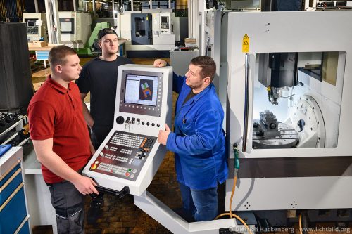 Ausbilder erklärt die 5-Achs-Simultan Fräsmaschine in der CNC-Abteilung — Steinmüller Bildungszentrum in Gummersbach