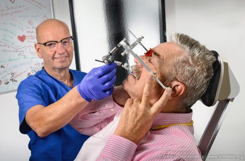 Mithilfe des Gesichtsbogens sammelt der Arzt möglichst detaillierte Informationen, um eine Vollprothese anzufertigen.